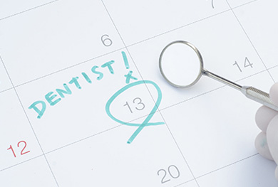 The image shows a calendar with the word  dentist  circled and marked with an exclamation mark, accompanied by a magnifying glass, suggesting a focus on dental health appointments.